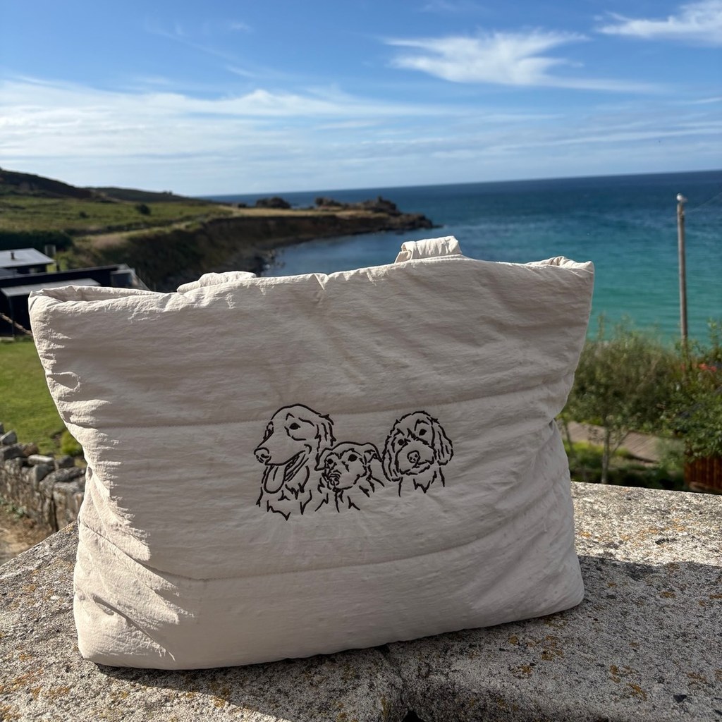 Cream tote bag embroidered with three dog portraits by the sea